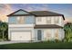 Charming two-story home boasts a two-car garage, inviting front porch, and beautifully landscaped yard at 9832 Crescent Moon Dr, Riverview, FL 33578