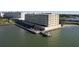 Aerial view of waterfront condo complex with pier extending into the bay and water views at 100 Bluff View Dr # 502C, Belleair Bluffs, FL 33770