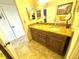Bathroom featuring double sinks with granite countertop and wood cabinetry at 100 Bluff View Dr # 502C, Belleair Bluffs, FL 33770