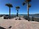 Waterfront dock with seating, palm trees, and a view of the clear blue sky at 100 Bluff View Dr # 502C, Belleair Bluffs, FL 33770