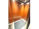 Interior elevator with wood paneled walls, a grab bar, and gray floor mat at 100 Bluff View Dr # 502C, Belleair Bluffs, FL 33770