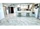 Open-concept kitchen boasts an island with seating, complemented by modern appliances and elegant marble tile flooring at 100 Bluff View Dr # 502C, Belleair Bluffs, FL 33770