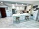 Bright kitchen with white cabinets, stainless steel appliances, island with seating, and stylish marble flooring at 100 Bluff View Dr # 502C, Belleair Bluffs, FL 33770
