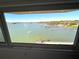 Beautiful waterfront view from a condo showcasing the harbor, boats, and lush greenery through a large window at 100 Bluff View Dr # 502C, Belleair Bluffs, FL 33770