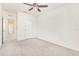 Airy bedroom with plush carpet and modern ceiling fan, plus a glimpse into the hall beyond the open door at 10506 Penny Gale Loop, San Antonio, FL 33576