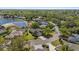 Aerial view of a home near a lake, surrounded by lush trees and well-maintained streets at 11234 Rivers Bluff Cir, Lakewood Ranch, FL 34202