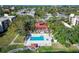 An aerial view of the community pool, community center, trees, and surrounding neighborhood at 11485 Oakhurst Rd # A202, Largo, FL 33774