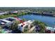 Aerial view of condo building with a pond, community pool, and mature trees at 11485 Oakhurst Rd # A202, Largo, FL 33774