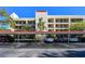 Exterior view of the four-story condo building with covered parking and well-maintained landscaping at 11485 Oakhurst Rd # A202, Largo, FL 33774
