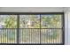 Balcony with metal rails overlooking green community landscape with mature trees at 11485 Oakhurst Rd # A202, Largo, FL 33774