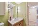 Bathroom with vanity including sink, countertop, mirror, and light fixture and hallway leading into the kitchen at 11485 Oakhurst Rd # A202, Largo, FL 33774