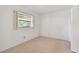Clean bedroom with a neutral carpet, bright window, and closet space at 11485 Oakhurst Rd # A202, Largo, FL 33774