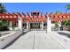 Community center exterior with pergola, patio furniture, grill, and walkways leading to the entrance at 11485 Oakhurst Rd # A202, Largo, FL 33774