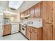 Spacious kitchen featuring modern white appliances and natural wood cabinets at 11485 Oakhurst Rd # A202, Largo, FL 33774