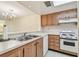 Open kitchen with stainless steel sink and modern white appliances at 11485 Oakhurst Rd # A202, Largo, FL 33774