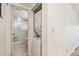 Hallway view of the laundry closet including stacked washer and dryer and partially-viewed bathroom with tub and shower at 11485 Oakhurst Rd # A202, Largo, FL 33774