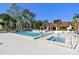 Community pool and hot tub with patio furniture surrounded by trees and the community center at 11485 Oakhurst Rd # A202, Largo, FL 33774