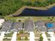 Aerial view of a neighborhood with landscaped yards, a serene pond, and homes with private backyards at 11872 Thicket Wood Dr, Riverview, FL 33579