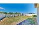 Backyard with a white picket fence, green grass, shed and Adirondack chairs around a fire pit at 11872 Thicket Wood Dr, Riverview, FL 33579