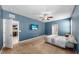 Carpeted bedroom with a mounted TV and an open view to the kitchen and bathroom at 11872 Thicket Wood Dr, Riverview, FL 33579