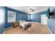 Cozy bedroom with a ceiling fan, a mounted TV, and plenty of natural light from large windows at 11872 Thicket Wood Dr, Riverview, FL 33579