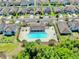 Aerial view of a community pool with plenty of lounge chairs in a residential neighborhood at 11872 Thicket Wood Dr, Riverview, FL 33579