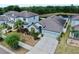 Aerial view of a light blue home with well-maintained landscaping, neutral driveway, and a two-car garage at 11872 Thicket Wood Dr, Riverview, FL 33579