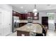 Modern kitchen with dark wood cabinetry, stainless steel appliances, a granite island, and ample counter space at 11872 Thicket Wood Dr, Riverview, FL 33579