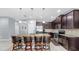Kitchen island featuring seating, granite countertops, and dark wood cabinets at 11872 Thicket Wood Dr, Riverview, FL 33579