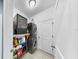 Neat laundry room features a stacked washer and dryer and convenient storage shelves for detergents and cleaning supplies at 11872 Thicket Wood Dr, Riverview, FL 33579
