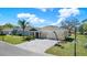 Single-story home featuring a three-car garage, a paver driveway, well-manicured lawn, and a basketball hoop at 12749 Flamingo Parkway, Spring Hill, FL 34610