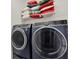 Laundry room showcasing a full-size washer and dryer and shelving for storage at 12749 Flamingo Parkway, Spring Hill, FL 34610