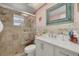 This bright bathroom includes a glass enclosed shower, decorator mirror, and accent tiles at 12821 5Th Isle, Hudson, FL 34667
