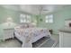 Light and airy bedroom with floral bedding, plantation shutters, and hardwood floors at 12821 5Th Isle, Hudson, FL 34667