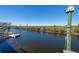 Scenic waterfront view featuring a dock, canal, and birdhouse on a clear, sunny day at 12821 5Th Isle, Hudson, FL 34667