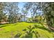 Spacious backyard with a well-manicured lawn and shade trees at 1908 Sutherland W Dr, Palm Harbor, FL 34683