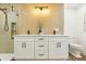 Bathroom featuring modern lighting, double sink vanity, and walk-in shower at 1908 Sutherland W Dr, Palm Harbor, FL 34683