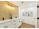 Bathroom with double sink vanity, wood-look tile flooring, and modern lighting at 1908 Sutherland W Dr, Palm Harbor, FL 34683