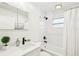 Well-lit bathroom featuring white subway tile, walk-in shower and modern vanity with black hardware at 1908 Sutherland W Dr, Palm Harbor, FL 34683