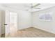 Well lit bedroom with wood-look tile flooring, neutral paint, and shuttered windows for natural light and privacy at 1908 Sutherland W Dr, Palm Harbor, FL 34683