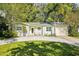 Charming single-story home featuring a lush landscaped yard, ample parking, and a welcoming front entrance at 1908 Sutherland W Dr, Palm Harbor, FL 34683