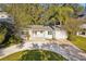 Inviting single-story home showcases a freshly graveled driveway, manicured lawn, and cozy seating area at 1908 Sutherland W Dr, Palm Harbor, FL 34683
