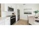 Contemporary kitchen with white cabinets, modern appliances, and a view of the adjacent dining area at 1908 Sutherland W Dr, Palm Harbor, FL 34683