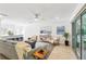 Open-concept living area with modern furnishings, sleek flooring, and a sliding glass door leading to outdoor space at 1908 Sutherland W Dr, Palm Harbor, FL 34683