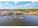 Aerial view of a marina with boats docked along the pier under a bright, partly cloudy sky at 1908 Sutherland W Dr, Palm Harbor, FL 34683