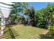 Grassy backyard with lush greenery and a pergola covered patio at 201 S Treasure E Dr, Tampa, FL 33609