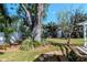 View of the backyard featuring a beautiful shade tree and lush lawn at 201 S Treasure E Dr, Tampa, FL 33609