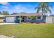 Charming one-story blue home with a well-manicured lawn and lovely palm trees enhancing its curb appeal at 2327 Moore Haven W Dr, Clearwater, FL 33763