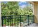 Enjoy the lush green views from this balcony featuring a decorative metal railing and exterior siding at 2676 Tanglewood Trl, Palm Harbor, FL 34685