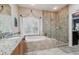 This spacious bathroom has a luxurious soaking tub and a glass-enclosed shower with gorgeous tile at 2676 Tanglewood Trl, Palm Harbor, FL 34685